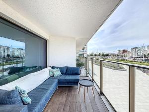 ein Wohnzimmer mit Couch und Balkon in der Unterkunft Flat Sky Harbour 104 - Oostende in Ostende