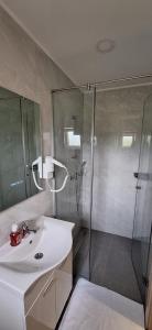 Un baño con ducha y lavabo blanco. en Apartmani Masline, en Međugorje
