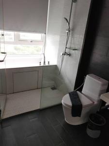a white bathroom with a shower and a toilet at Veranda Residence Pattaya By Suia in Na Jomtien