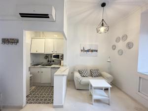 biały salon z kanapą i stołem w obiekcie Encantador apartamento en el centro de Sevilla w Sewilli