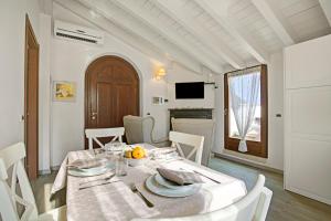ein Esszimmer mit einem Tisch und weißen Stühlen in der Unterkunft Agriturismo Cascina Crocelle - Lake View and Heated Pool in Padenghe sul Garda