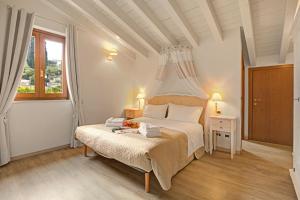 a white bedroom with a bed with a canopy at Agriturismo Cascina Crocelle - Lake View and Heated Pool in Padenghe sul Garda