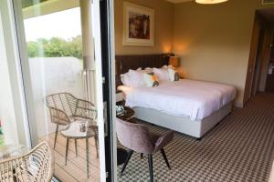 una camera d'albergo con un letto e un balcone di voco The Club a Naas