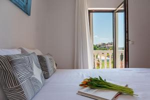 a book and vegetables on a bed with a window at Holiday apartments by the sea in Funtana