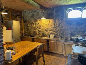 a kitchen with a wooden table and a refrigerator at Denderi in Vaidava +6 photos