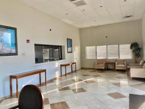 a lobby with a waiting room with chairs and a tv at Motel 6 Forrest City AR in Forrest City