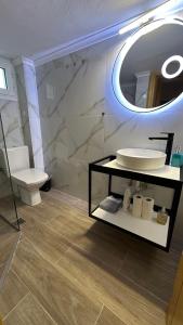 łazienka z umywalką, toaletą i lustrem w obiekcie Elena apartment chalkidiki w mieście Kallithea