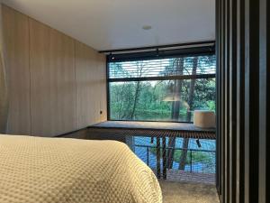 a bedroom with a bed and a large window at Aura Glemp & SPA in Laukbeitini