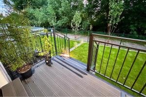 eine Holzterrasse mit Pflanzen und einem Zaun in der Unterkunft Apartment Paradise in Świnoujście