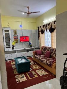 a living room with a couch and a tv at 2BHK Cozy Apartment Near IKEA & BIEC Bangalore in Bengaluru