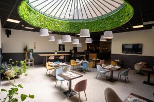 a restaurant with tables and chairs and a domed ceiling at Hôtel d'Angleterre, Salon-de-Provence in Salon-de-Provence