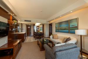 a living room with a couch and a tv at Shangri-La Shenzhen in Shenzhen
