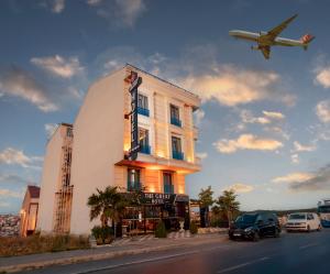 an airplane is flying over a building with a hotel at The Great Airport Hotel in Arnavutköy
