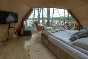 a bedroom with a bed and a balcony with a television at Hotel Tajty in Giżycko