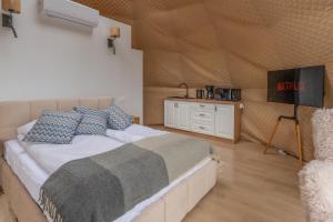 a bedroom with a bed and a television in it at Hotel Tajty in Giżycko