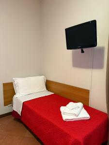 a bedroom with a red bed with a tv on the wall at Villa Francesca Pomezia Roma in Pomezia +34 photos
