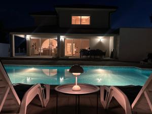 a house with a swimming pool at night at Villa Elezovic in Čapljina