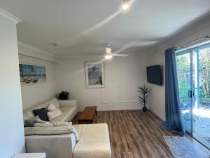 a living room with a couch and a table at Bruns Beach Garden Apartment - Central, Comfortable & Close to the beach in Brunswick Heads