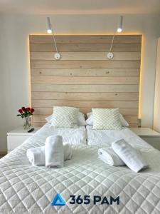 une chambre avec un grand lit avec des draps et des oreillers blancs dans l'établissement 365PAM - Studio Białe i Czarne w Dominikanie Przy Morzu, à Sianożęty