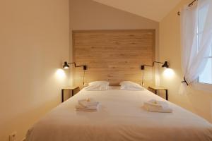 a bedroom with a large white bed with two towels on it at Les Collines Iduki in Labastide-Clairence