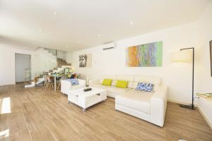 a living room with a white couch and a table at Villa Jade I in Can Picafort