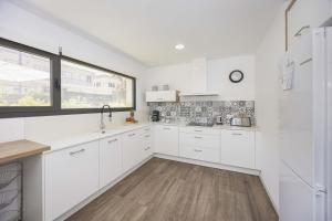 a white kitchen with white cabinets and a window at Villa Jade I in Can Picafort +36 photos