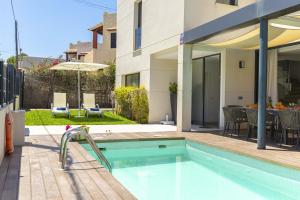 a house with a swimming pool next to a building at Villa Jade I in Can Picafort