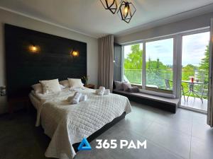 une chambre avec un grand lit et une grande fenêtre dans l'établissement 365PAM - Studio Białe i Czarne w Dominikanie Przy Morzu, à Sianożęty