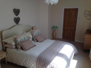 a bedroom with a large white bed with pillows at Apartment One in Beer