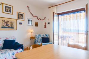 a living room with a table and a couch and a window at Appartamento Vista Nel Mare Blu in Rio nellʼElba