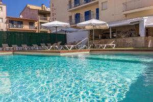 a large swimming pool with chairs and umbrellas at Hotel Bell Aire in L'Estartit