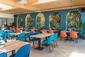 TILIA Resort في دولني كوبين: مطعم بطاولات خشبية وكراسي زرقاء