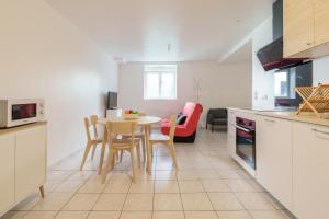 a kitchen and dining room with a table and chairs at Au pied du château - Proche gare Lunéville in Lunéville +4 photos