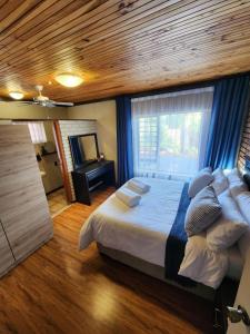 una camera da letto con un letto grande e una finestra di Addo Bush & Bay Cottage a Gqeberha
