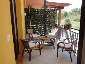 Un patio con sillas y una mesa en el balcón. en Baciati Dal Sole, en Porto Empedocle