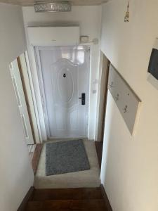a hallway with a white door and a rug at Milić apartmani 2 in Kuršumlija