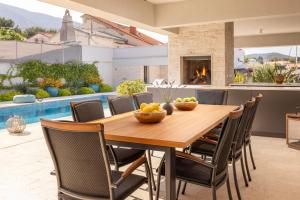 a kitchen and dining room with a wooden table and chairs at Villa Amorosa, Luxury Villa with Large heated Pool & Sea View, Lošinj Island in Nerezine