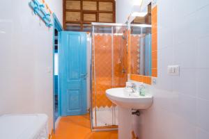a bathroom with a sink and a blue door at Alghero Bastioni colombo sea view in Alghero +63 photos