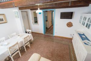 a room with a table and chairs and a tv at Alghero Bastioni colombo sea view in Alghero