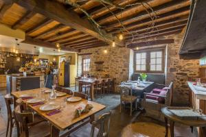 a dining room with tables and chairs in a building at Les Fous du Village in Saint-Esteben
