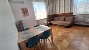 a living room with a table and chairs and a couch at Apartament VINCENT in Mrągowo