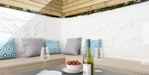 una mesa con dos copas de vino y un tazón de fruta en VITAMYN SEA, 4 bed house, Sleeps 8, Sea views, 5 min walk to harbour and beaches, en St Ives