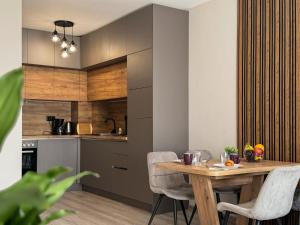プロブディフにあるModern 1BR Apartment with Free Street Parking and free Gym Passの木製のテーブルと椅子のあるキッチンとダイニングルーム