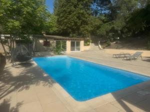 Una piscina con agua azul en un patio. en Pervenche, en Marsella