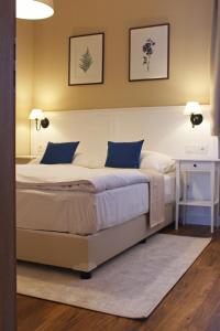 a bedroom with a large bed with blue pillows at Erhardt Superior Rooms in Sopron