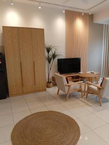 a living room with a table and chairs and a tv at Youth City Residence, Studio MUJI theme in Nilai