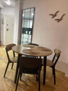 a dining room table with chairs and birds on the wall at Apartament z widokiem na morze Cabo Roig in Orihuela Costa
