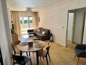 a living room with a couch and a table and chairs at Apartament z widokiem na morze Cabo Roig in Orihuela Costa