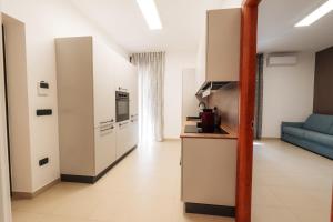 una cucina e un soggiorno con divano blu di B&b Dante a Gravina in Puglia