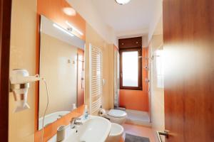 un bagno con lavandino, WC e specchio di B&b Dante a Gravina in Puglia Altre 16 foto